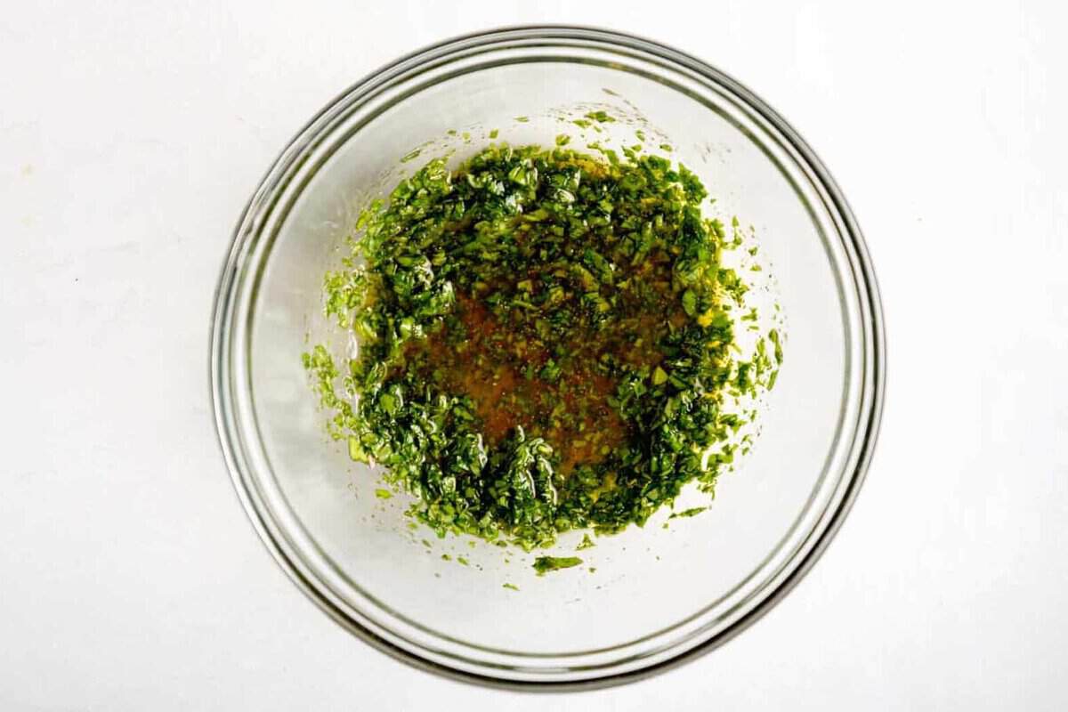 Dressing for cucumber tomato salad in bowl.