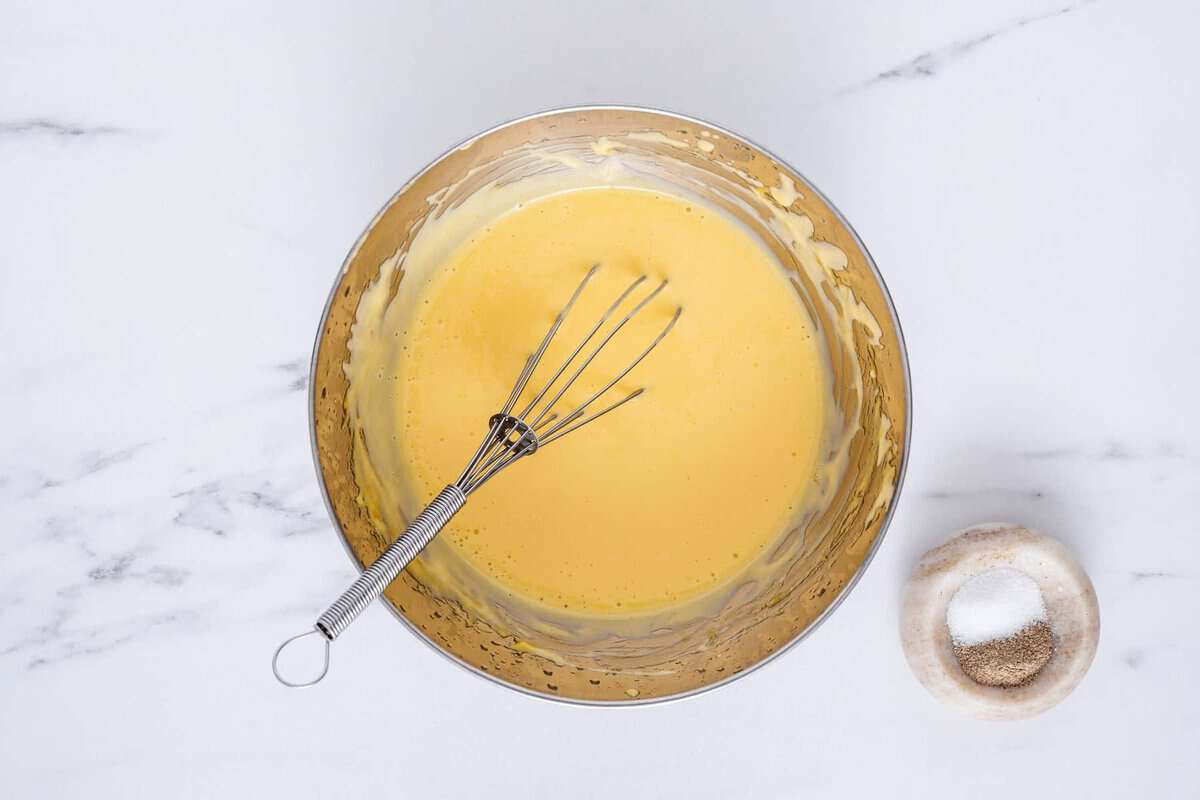 Whisking hollandaise sauce in bowl.