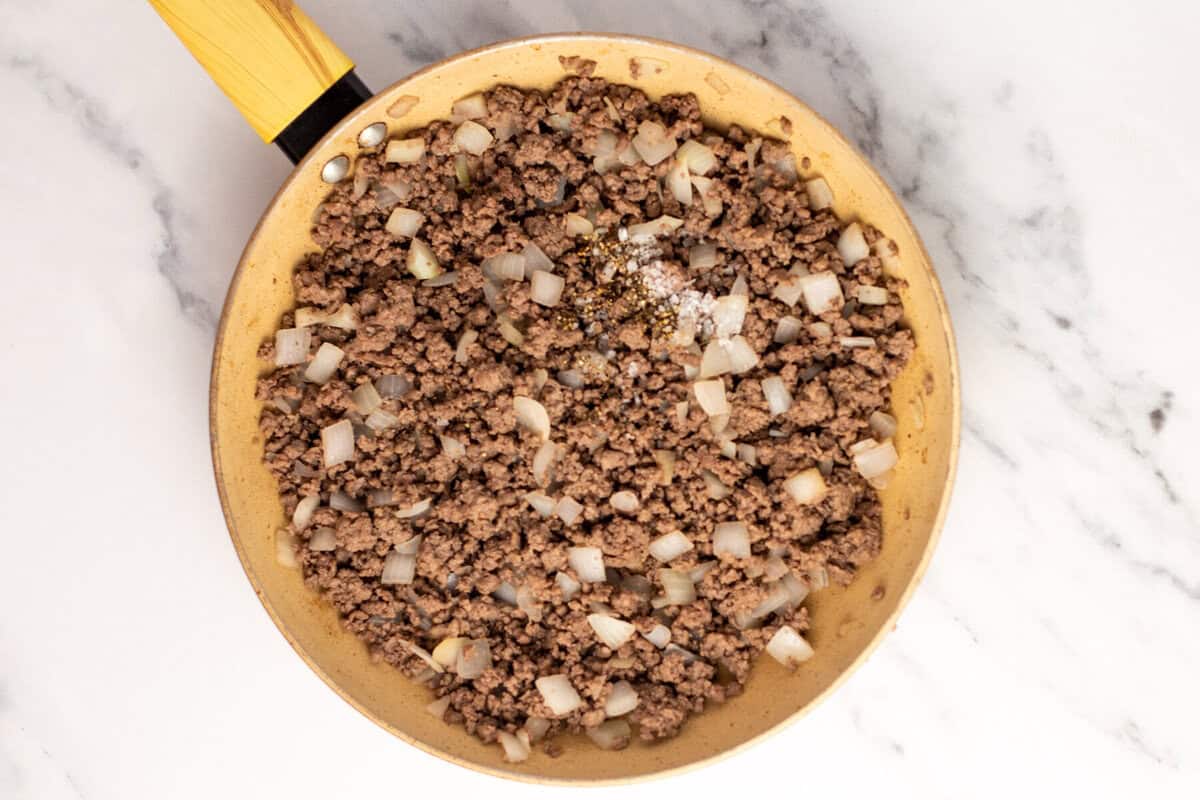Ground beef and onions in skillet.