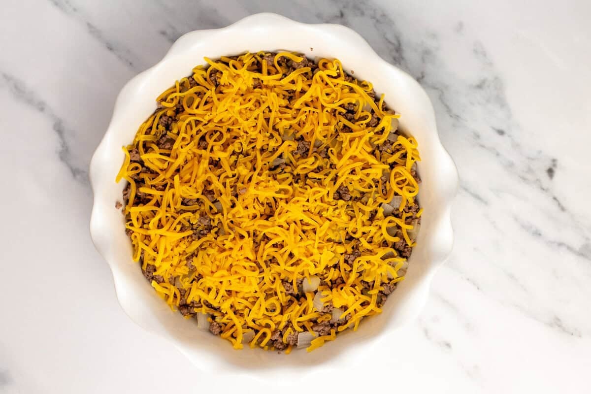 Ground beef and cheese in dish.