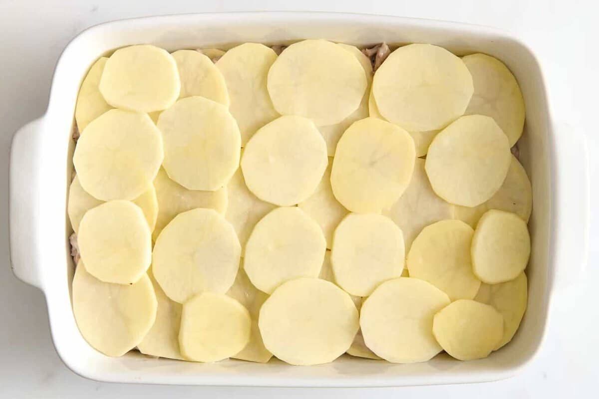 Potatoes layered in casserole dish.