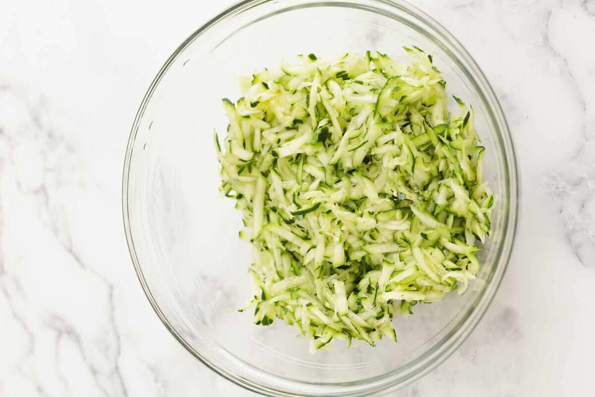 Shredded zucchini in bowl.