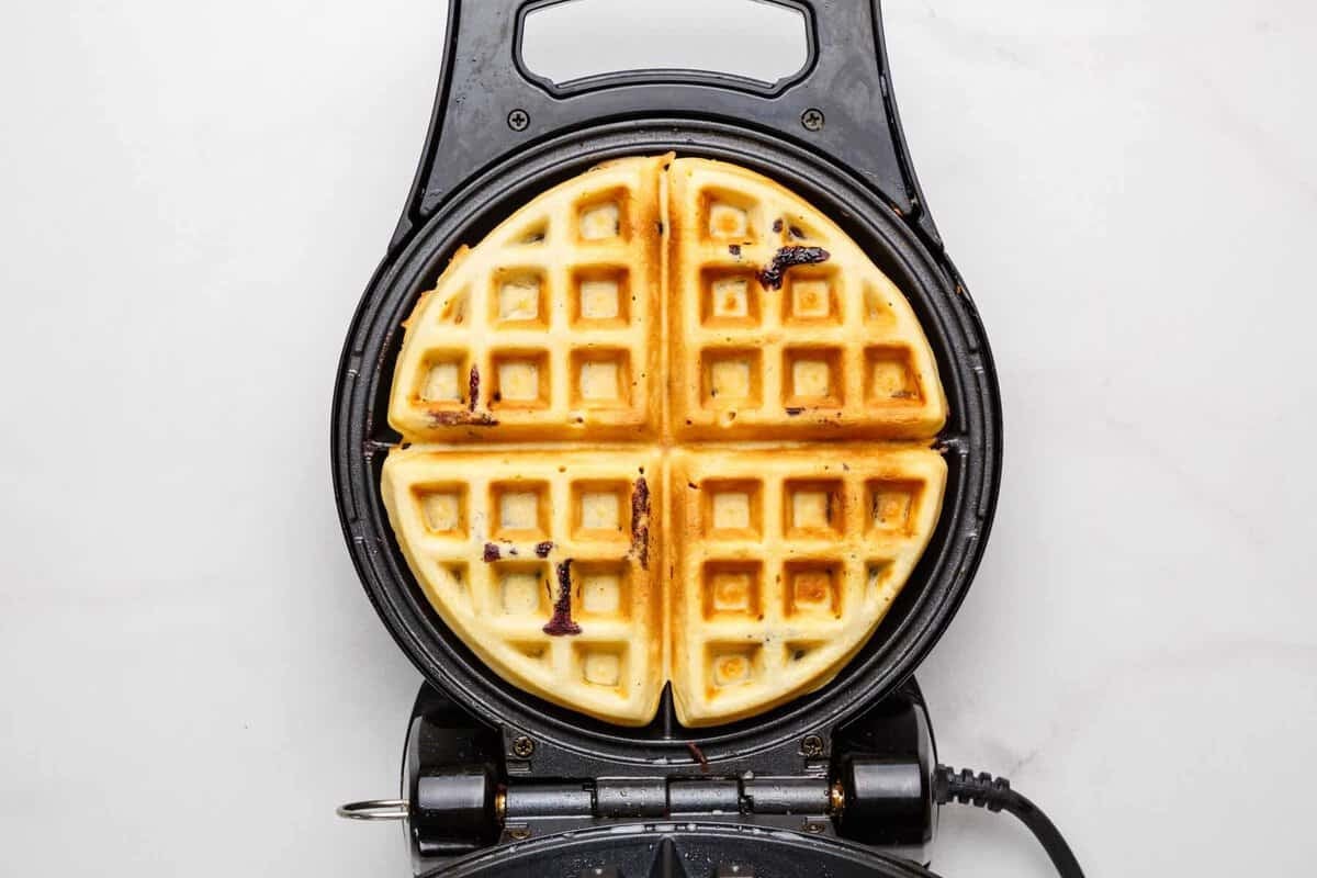 Blueberry waffle in waffle maker.
