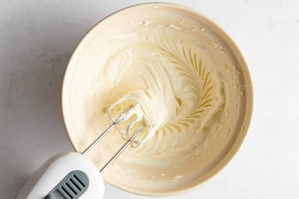 Cream cheese filling being beaten in mixing bowl.