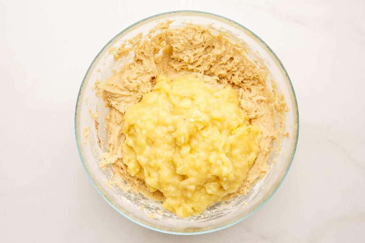 Mashed banana added to bowl of batter.