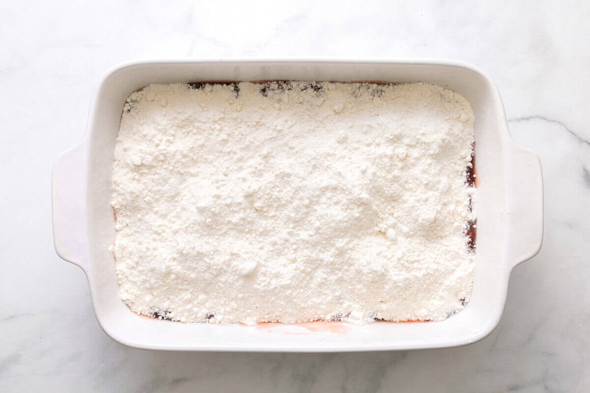Cake mix added to baking dish.