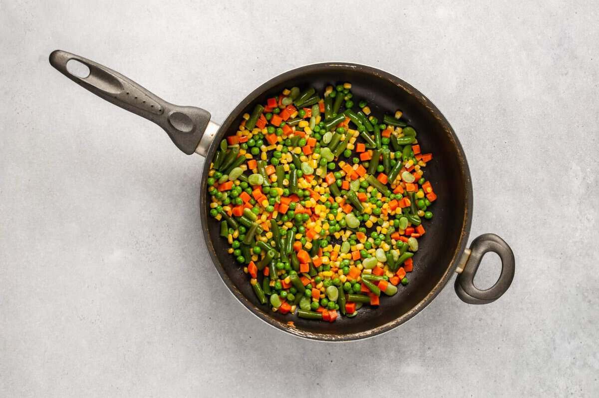 Vegetables cooking in skillet.