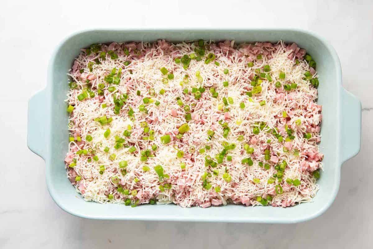 Ham, cheese, and green onions added to casserole dish.